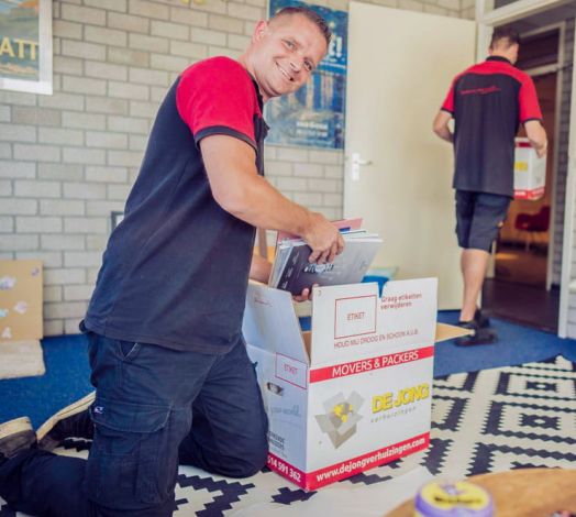 Professionele verhuizer pakt spullen in verhuis- en opslagdozen.